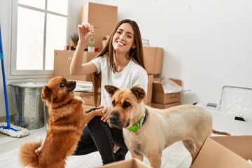 Young hispanic woman smiling confident holding key of new house at new home