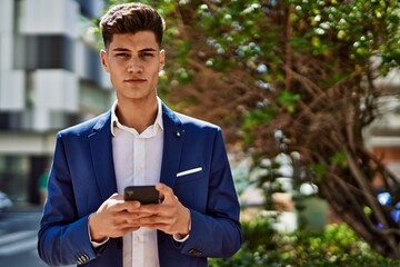 Young man using smartphone wearing suit at park