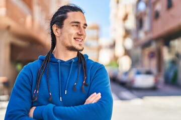 Fototapeta premium Young man smiling confident standing with arms crossed gesture at street
