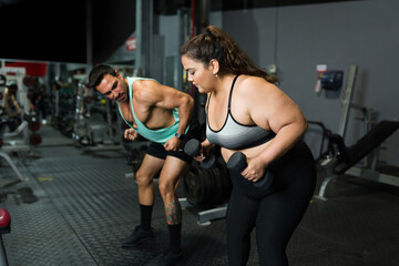Fitness coach and fat woman exercising