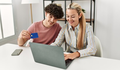 Obraz premium Young couple buying using laptop and credit card at home.