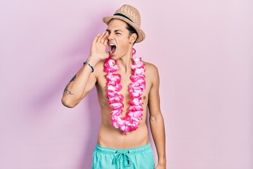 Young hispanic man wearing swimwear and summer hat shouting and screaming loud to side with hand on mouth. communication concept.