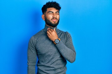 Arab man with beard wearing turtleneck sweater touching painful neck, sore throat for flu, clod and infection