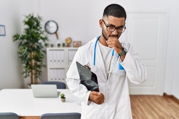 Young indian man wearing doctor uniform and stethoscope feeling unwell and coughing as symptom for cold or bronchitis. health care concept.