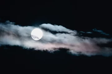Photo sur Aluminium Pleine lune Blurry unfocused Full moon in the night sky hidden behind clouds tinted with sunset light