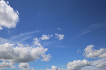 Naklejka na ściany i meble Blue clear summer sky background, white fluffy cumulus clouds, copy space