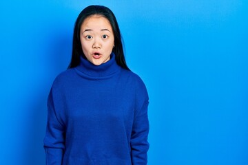 Fototapeta premium Young chinese girl wearing casual clothes afraid and shocked with surprise expression, fear and excited face.