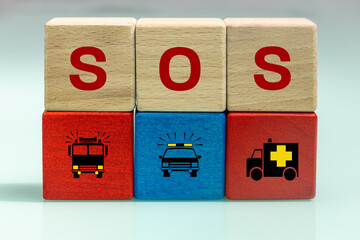 Wooden blocks with SOS inscription and icons of fire department, police and ambulance, Rescue...