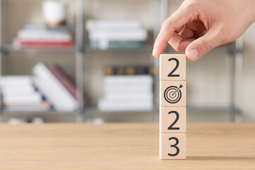 2023 new year goal planning idea, wood block cube with new year 2023 and target icon, business...
