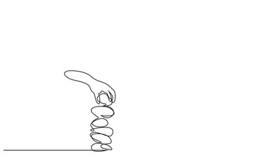 a person who balances stones on top of each other puts another stone on top