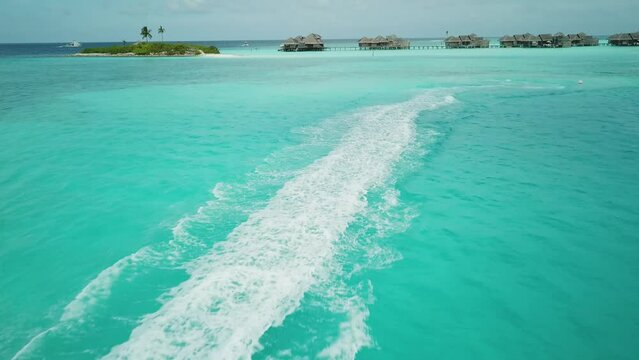 Aerial view of jet ski racing on a crystal clear turquoise water. Enjoying summer vacation in Maldives on a jet ski. Activity in Maldives. Close-up footage of a jet ski in a full speed. 4K video.