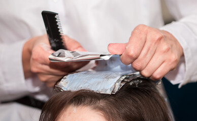 Hairdresser stylist takes care of girl's hair. Hair care procedures in a beauty salon. Hair...