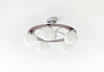 Brown chandelier with five white lampshades