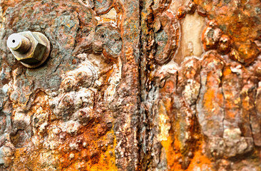 grunge background, iron rust occurs on a brown metal nut
