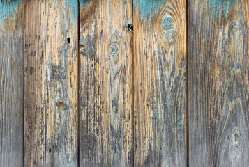 The texture of an old weathered wooden wall with remnants of blue paint. Wooden background with a space to copy.