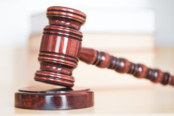 Judge gavel with books on light wooden table