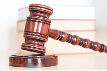 Judge gavel with books on light wooden table