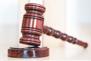 Judge gavel with books on light wooden table