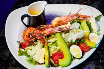 Salad with avocado, tiger prawns, tomatoes and quail eggs