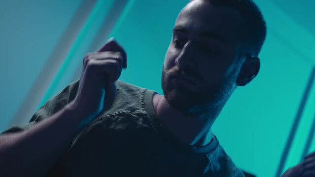 A music producer is dancing in a music studio. A man on drugs. Electonic music.