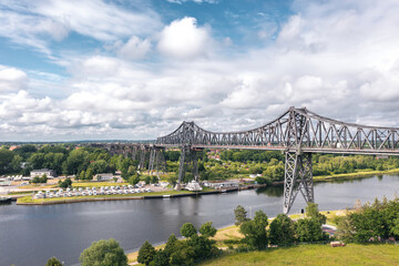 Fototapeta premium Rendsburg (Schleswig-Holstein, Germany) High Bridge (Rendsburger Hochbrücke) railway viaduct (Neumünster–Flensburg line) with Schwebefähre transporter bridge over Kiel Canal