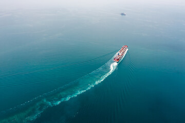 container ship sailing full speed to transport goods in containers for import export internationally and worldwide, business services transportation by container ship open sea, photograph aerial view