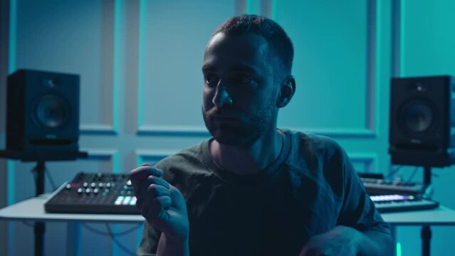 A music producer is dancing in a music studio. A man on drugs. Electonic music.