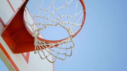 Basketball court outdoors, orange hoop, white net and backboard for basket ball game outside....