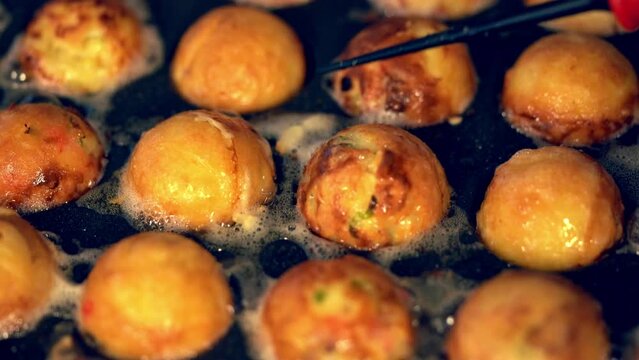 油で揚げられるようにカリカリに焼かれるたこ焼きの動画
