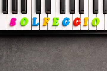 The word solfeggio is composed of multicolored letters on the piano keys. Copy space.	