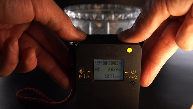 Man hand move, use dosimeter of ionizing radiation. Overdose in the old Soviet crystal vase. Concept of dangerous objects at home. Green light. assessment of particle level indicators.