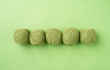 bright green yarn wool in a raw on bright background, top view flat lay
