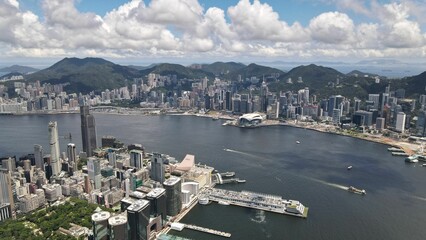 Panoramic shot of dense coastline skyscrapers under the cloudy sky in Hong Kong - Powered by Adobe