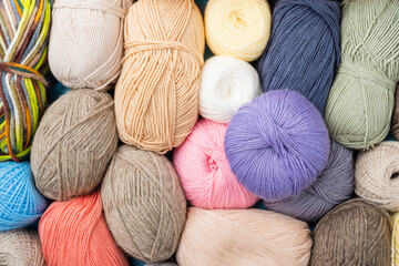 pastel colored yarn wool on shopfront. Knitting background, a lot of balls. Knitting yarn for...