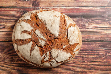 A loaf of crusty bread on rustic wooden table. 