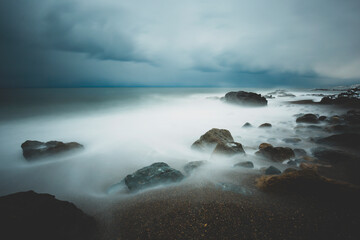 Obraz premium LONG EXPOSURE ON THE BEACH IN A BLACK SEA WAVY AND COLD WINTER DAY