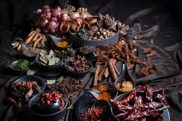 Various Thai and Chinese herbs in ceramic bowl on a dark background. Herbal and Spices Oriental marketplace.