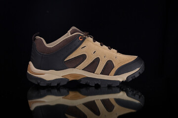 Male brown leather sneaker on blackground, isolated product.