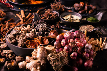 Shallots and various herbs and spices for cooking in bowls. Selective focus