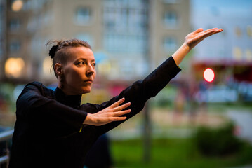 Asian woman trains tai chi in the city, chinese martial arts, healthy lifestyle concept.