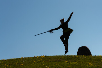 Asian woman with sword practicing taijiquan at sunset, chinese martial arts, healthy lifestyle...