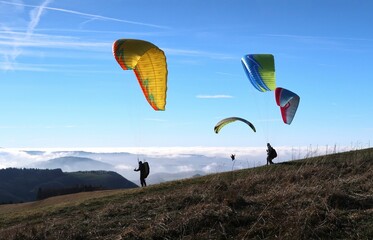 People paragliding on a sunny day at Wasserkuppe in Rhoen Germany