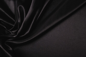 Abstract monochrome elegant luxury cloth background. Black color background with drapery and wavy...
