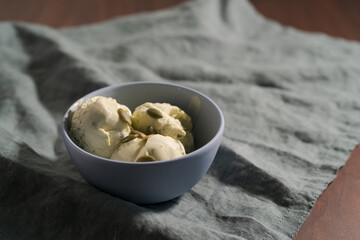 Pistachio ice cream with pumpkin seeds in bowl on table