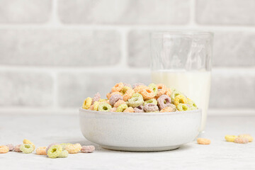 Traditional breakfast cereals with milk on a white table.  Bowl with  fruit oat rings in the kitchen  whith copy space