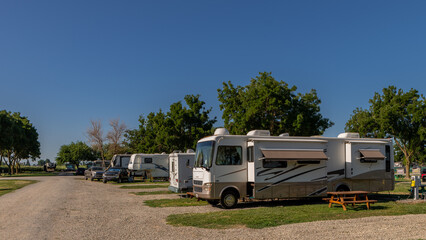 Rv campers at campsites on a sunny morning with blue skies - obrazy, fototapety, plakaty