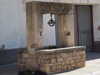 pozo de agua de consumo humano, origen medieval, construido en,  forma cuadrada,  estructura superior con polea para bajar el recipiente, tarragona, españa, europa 
