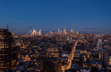 Fototapeta na wymiar Panoramic shot of metropolis after sunset. Tops of downtown skyscrapers lit by last rays of sun. Manhattan, New York City, USA