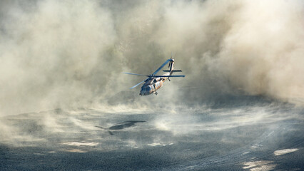 Hélicoptère militaire Black Hawk atterrissant ou décollant dans des nuages de poussière spectaculaires