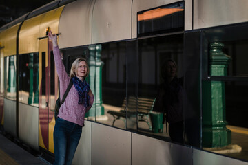 A woman meets a train on the platform.